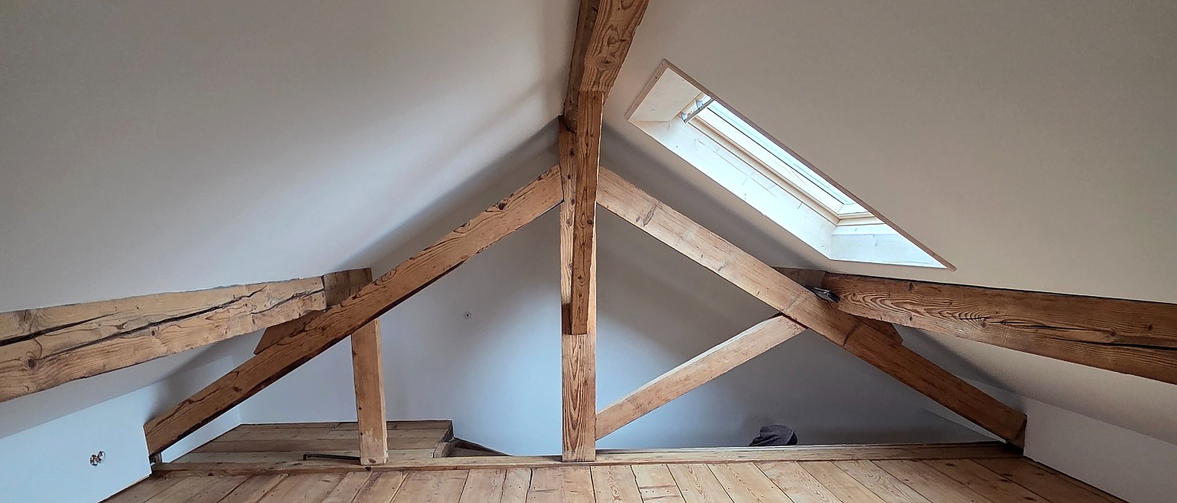 Charpente ancienne apparente et plancher bois dans des combles rénovés par Opus Bois